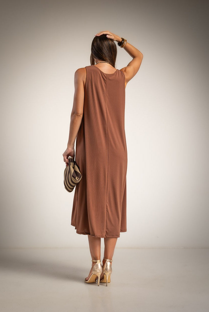 A woman is shown from behind wearing a sleeveless, brown midi dress