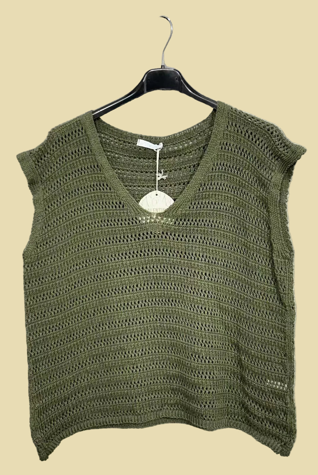Green knitted top on a hanger
