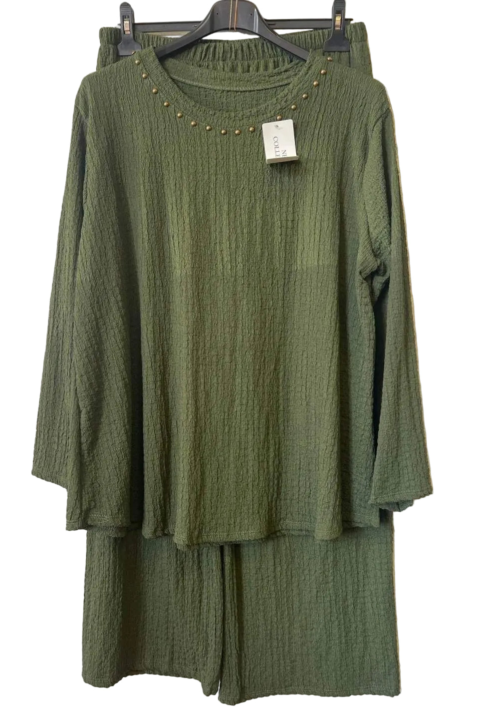 An olive green two-piece set consisting of a textured long-sleeve top with gold stud detailing around the neckline and matching textured pants,