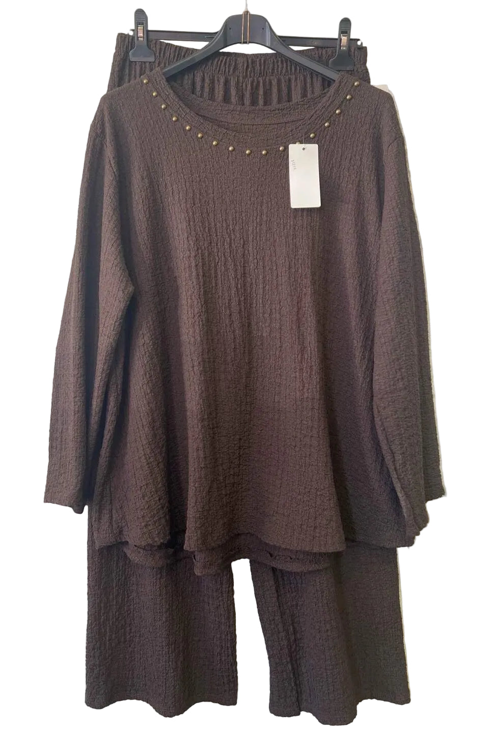 A dark brown two-piece matching set featuring a textured long-sleeve tunic top with gold stud detailing around the neckline and matching textured wide-leg pants