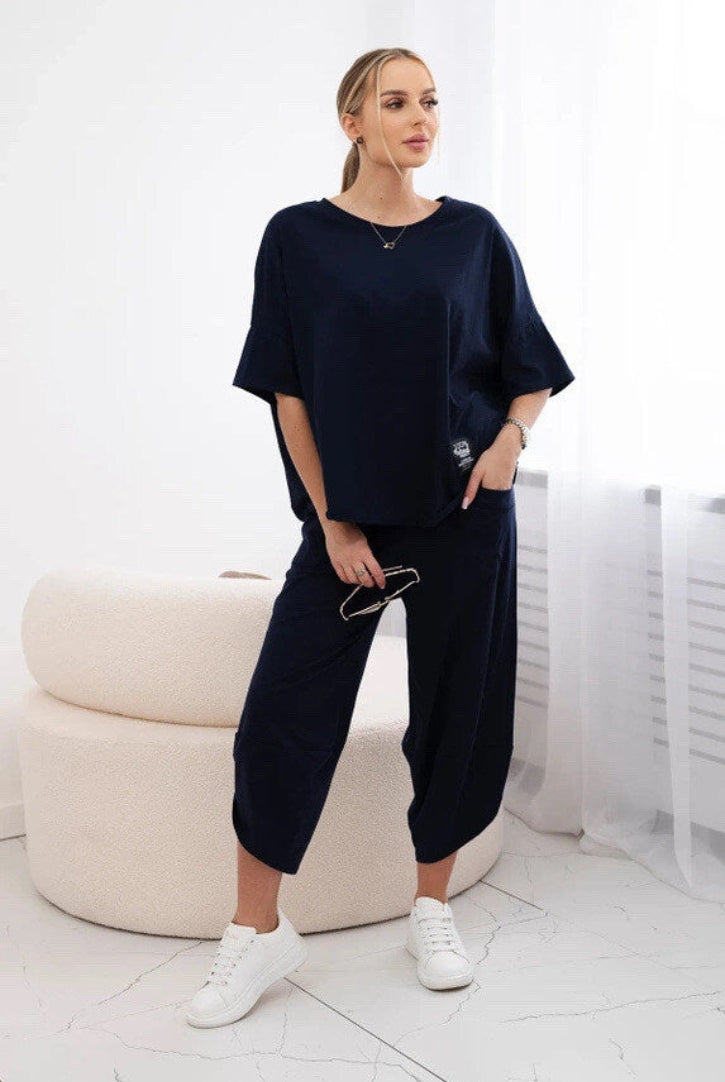 Woman wearing a navy blue outfit in a minimalistic room.