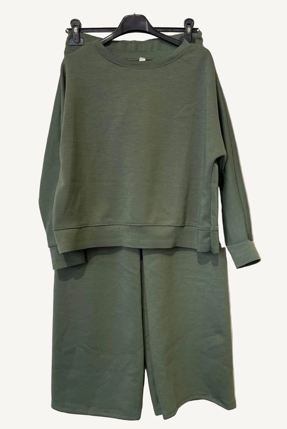 Green outfit with a sweatshirt and pants on a hanger