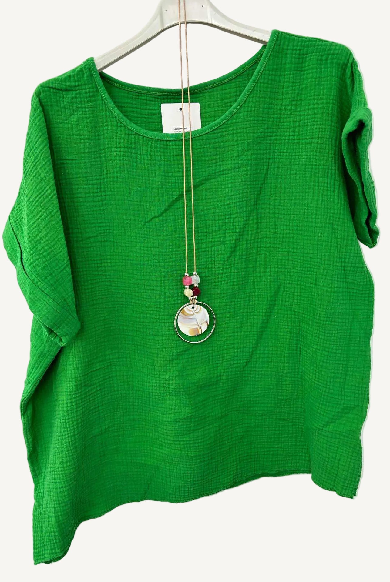 Green top with a necklace on a white background