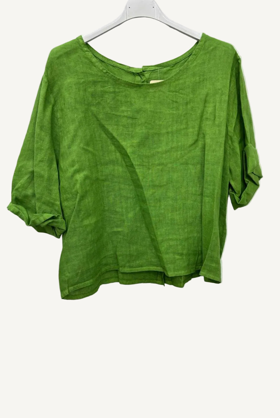 Green shirt on a hanger against a white background