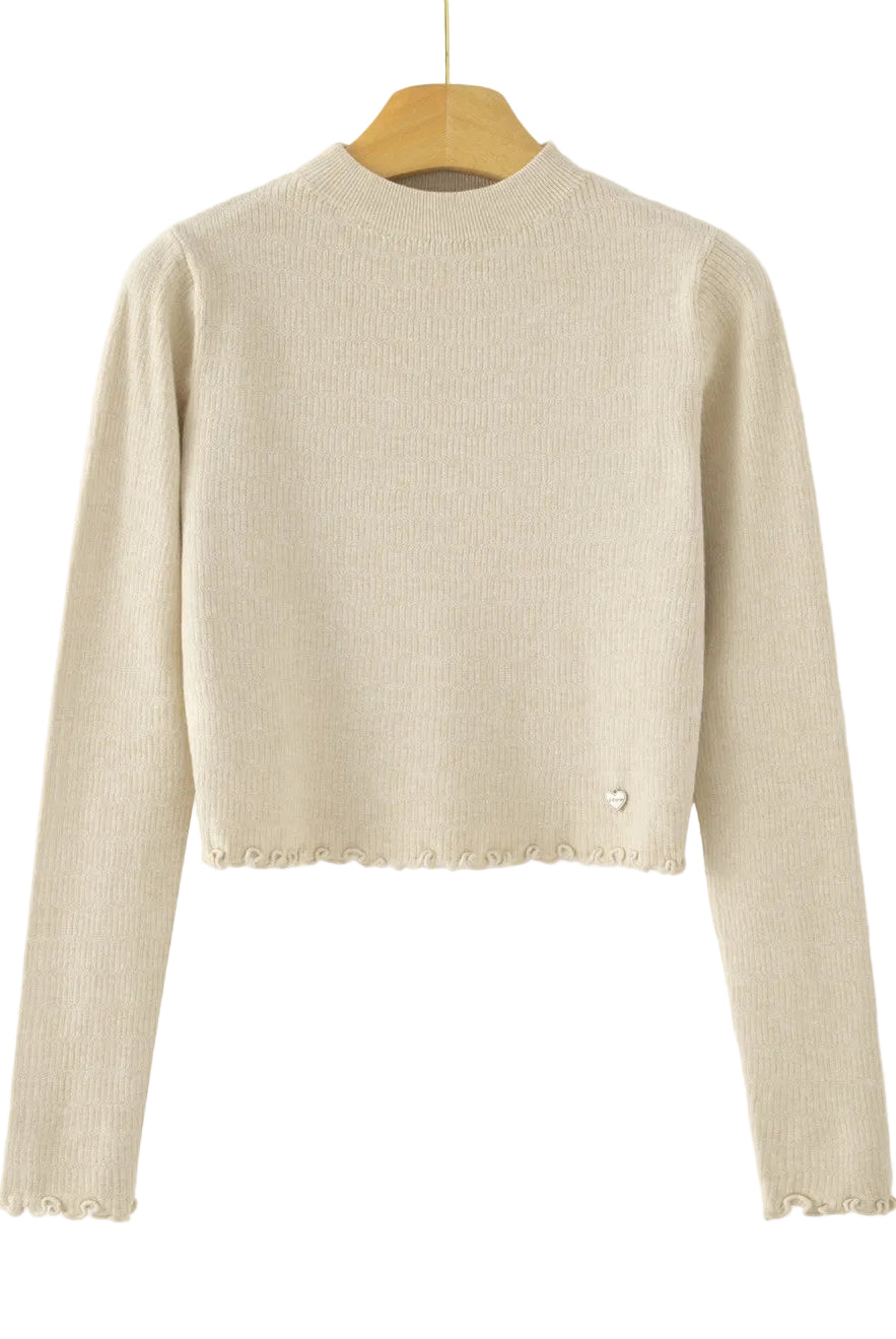 A beige ribbed knit long-sleeve crop top sweater hanging on a wooden hanger against a white background