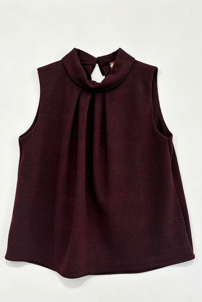 A sleeveless dark burgundy top with a high gathered mock neck and front pleats, laid flat against a light off-white background.