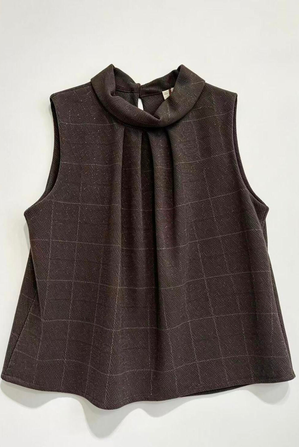 A sleeveless dark brown high-neck blouse with a subtle windowpane plaid pattern, displayed flat against a light off-white background.