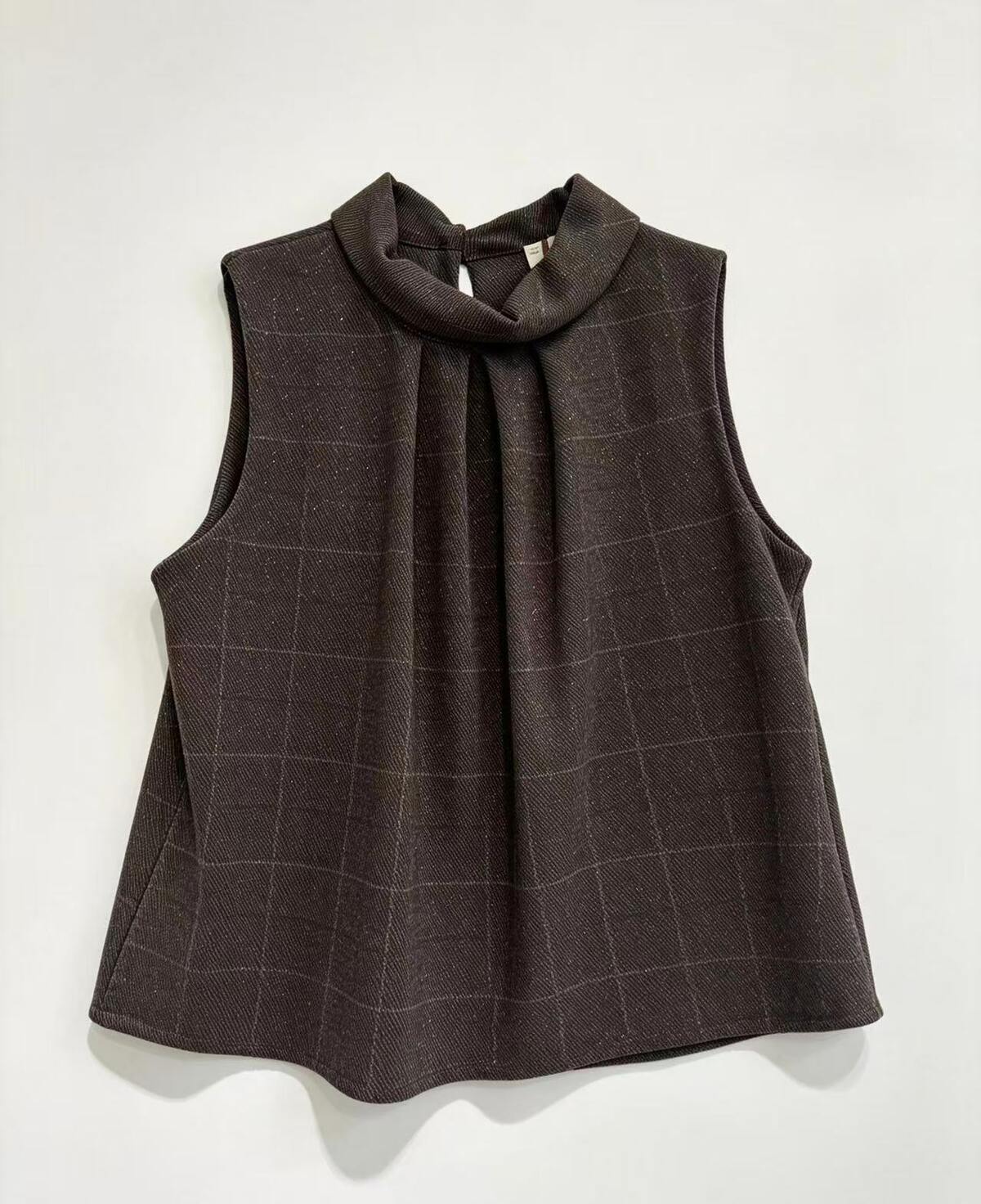 A sleeveless dark brown high-neck blouse with a subtle windowpane plaid pattern, displayed flat against a light off-white background.