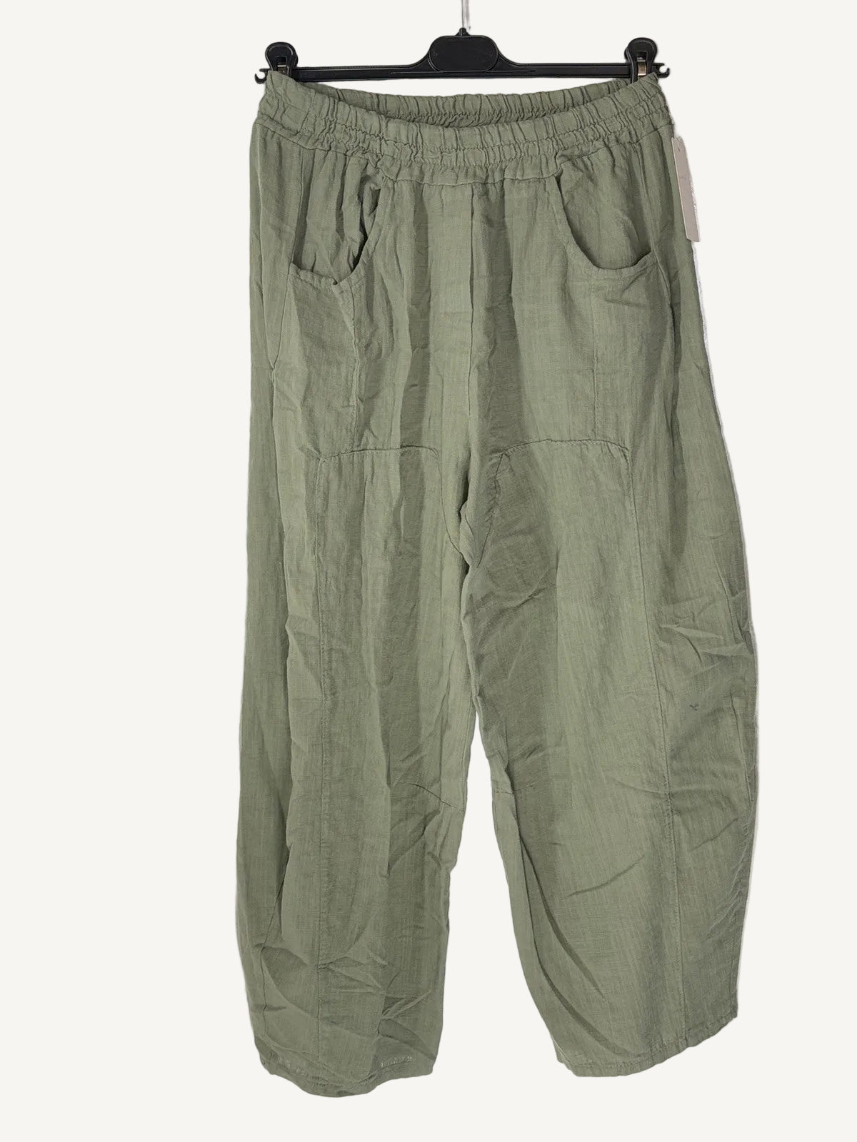 Green pants on a hanger against a white background