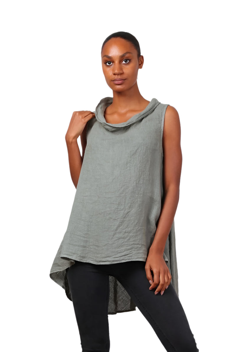 A woman wearing a khaki sleeveless cowl neck top with an asymmetrical hem, paired with white trousers.