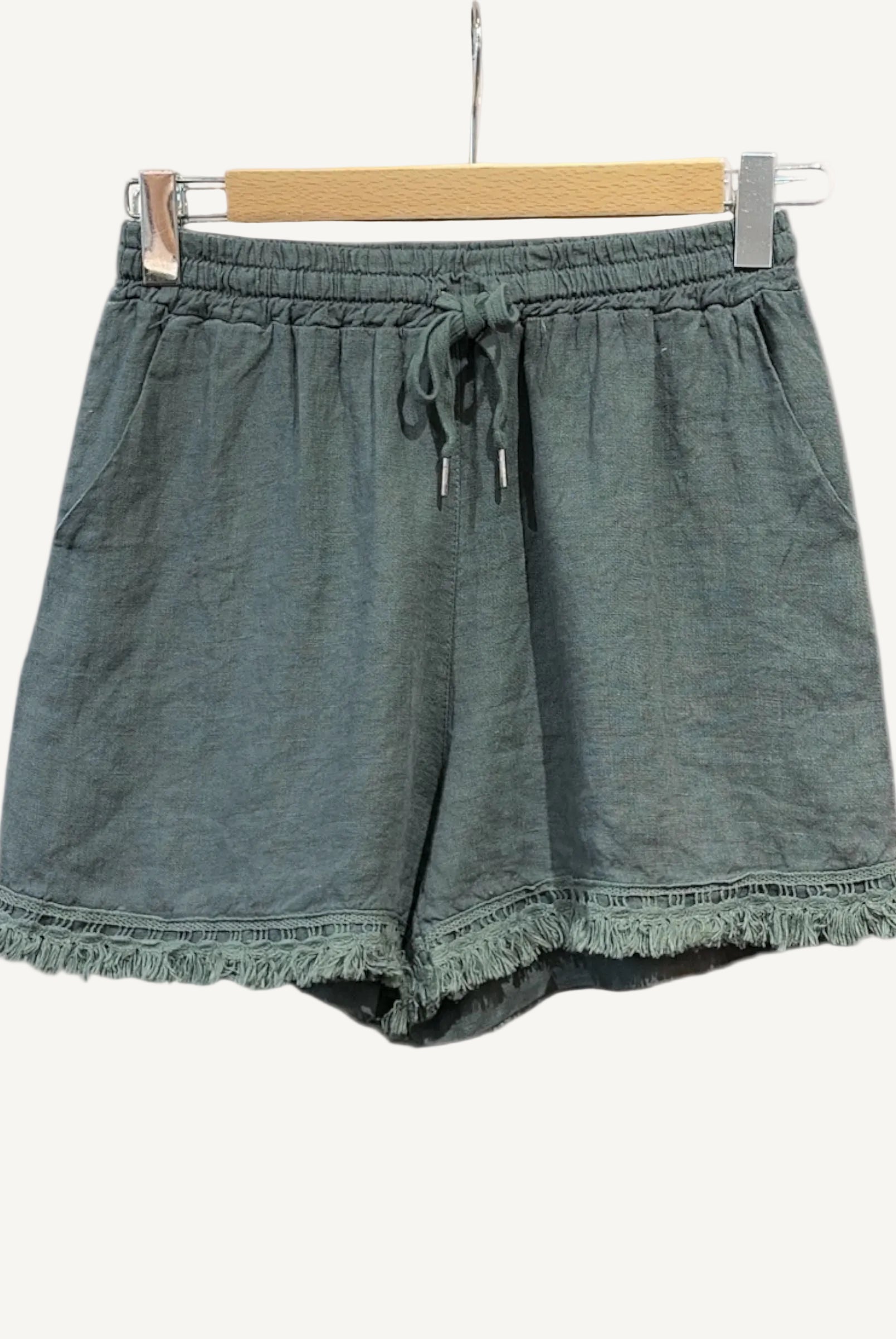 Green shorts with frayed hem on a white background