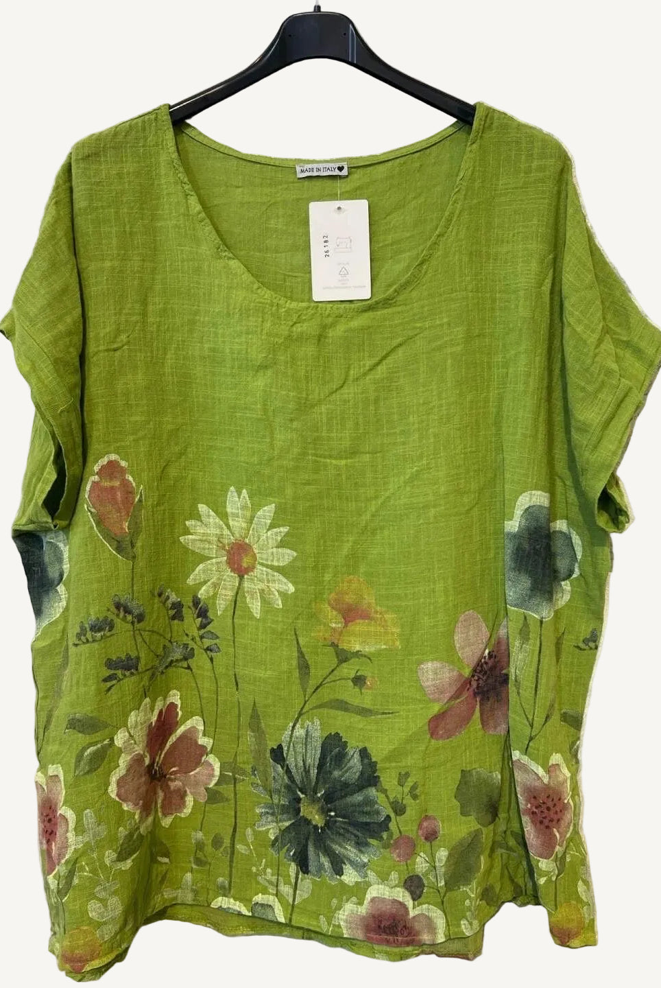 Lime Green floral top on a hanger against a textured white background