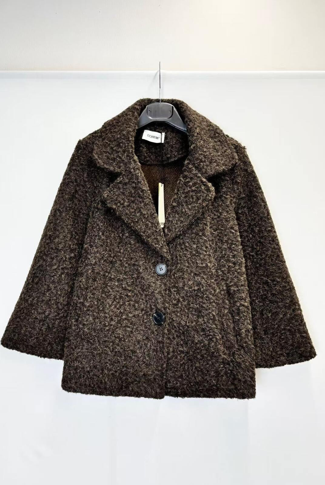 A brown textured bouclé coat with a single button closure, hanging on a black hanger against a plain white background.