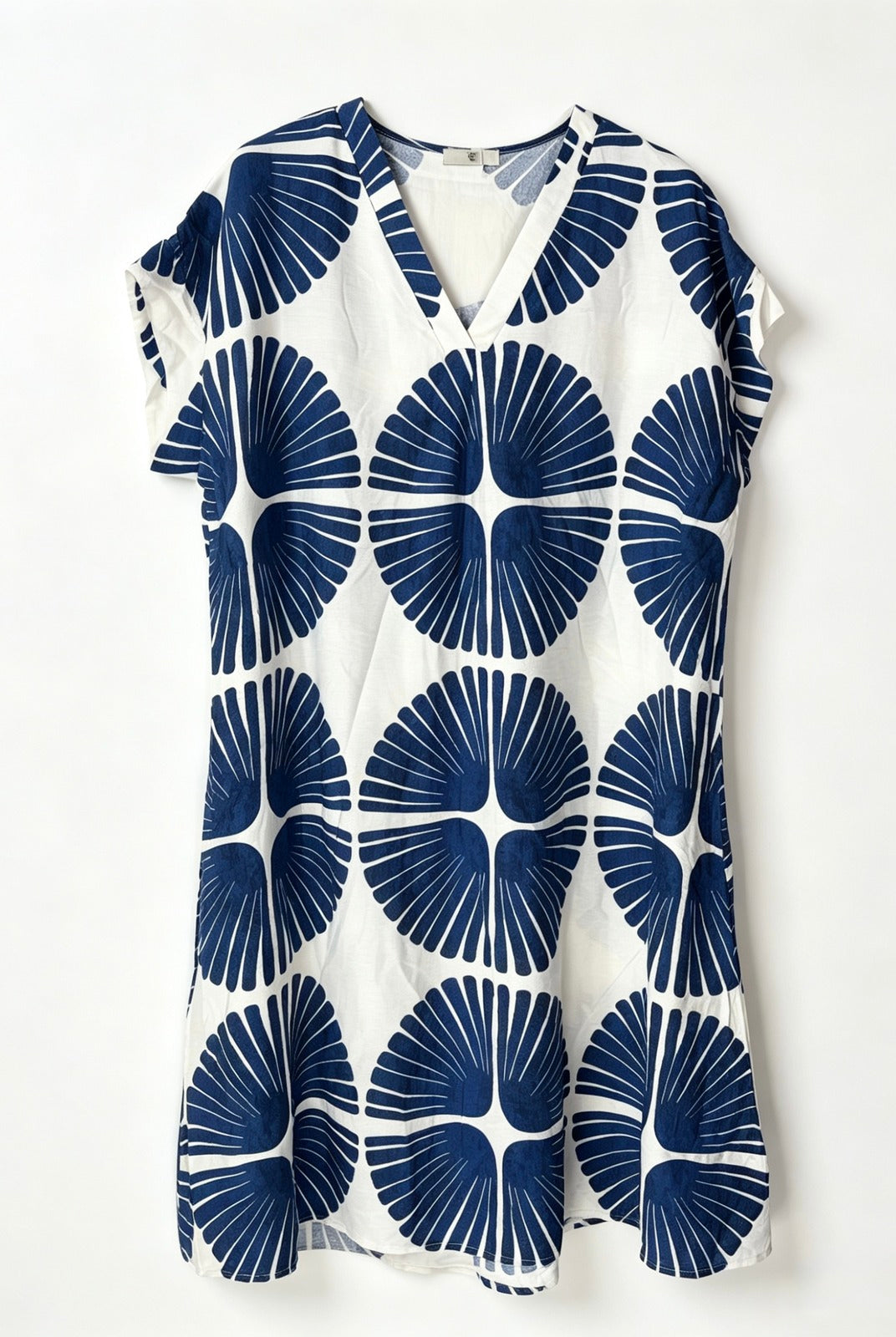 A short-sleeve V-neck dress featuring a bold navy blue and white geometric fan pattern, displayed flat against a clean white background.