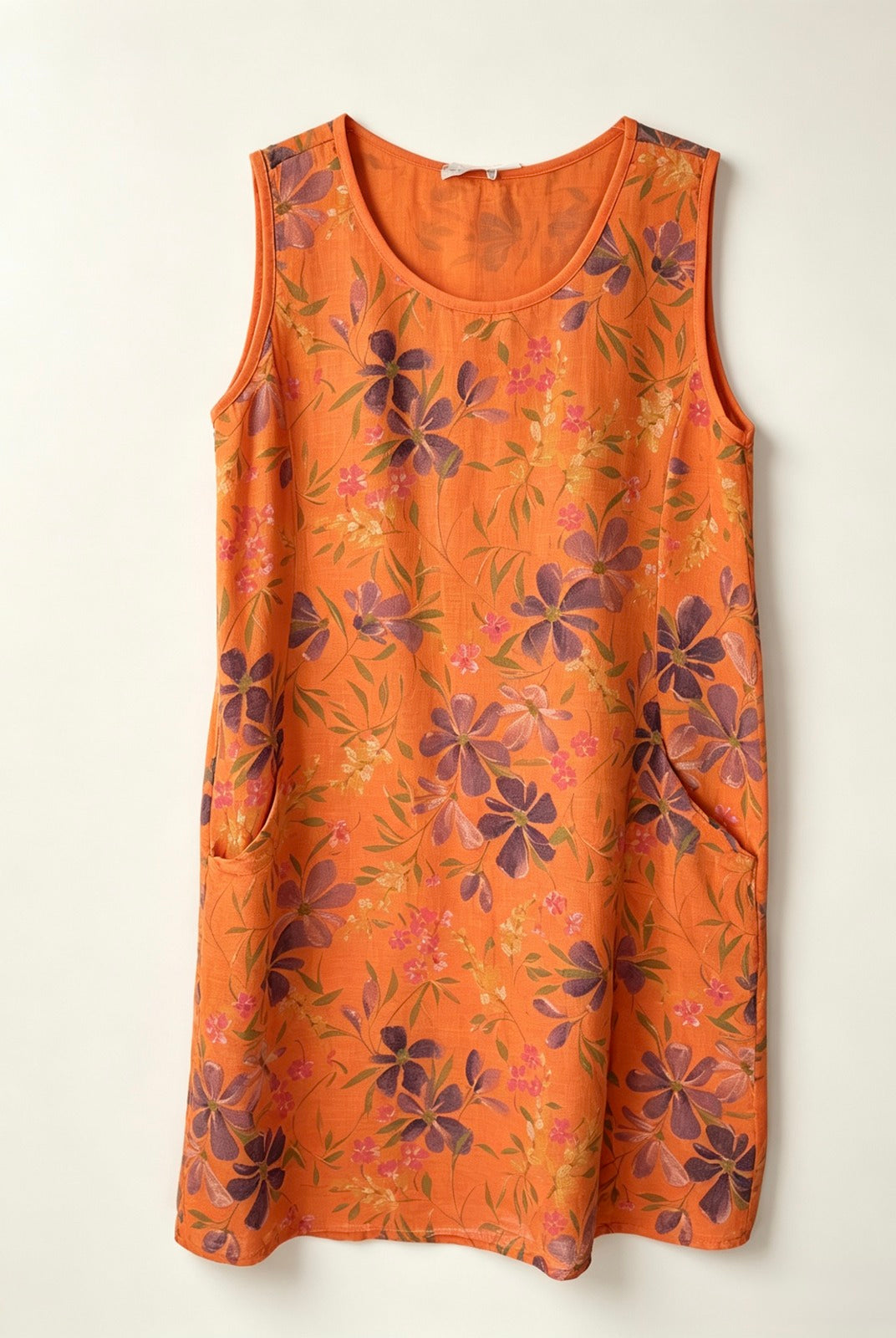 An orange sleeveless shift dress with a floral pattern