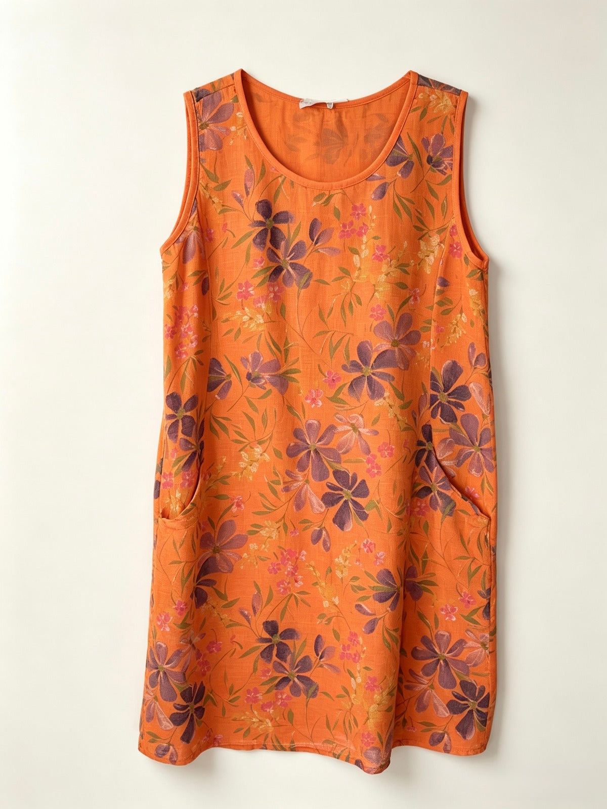 An orange sleeveless shift dress with a floral pattern