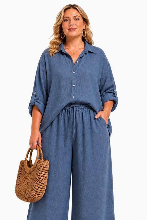 Woman wearing a blue outfit holding a woven bag on a white background