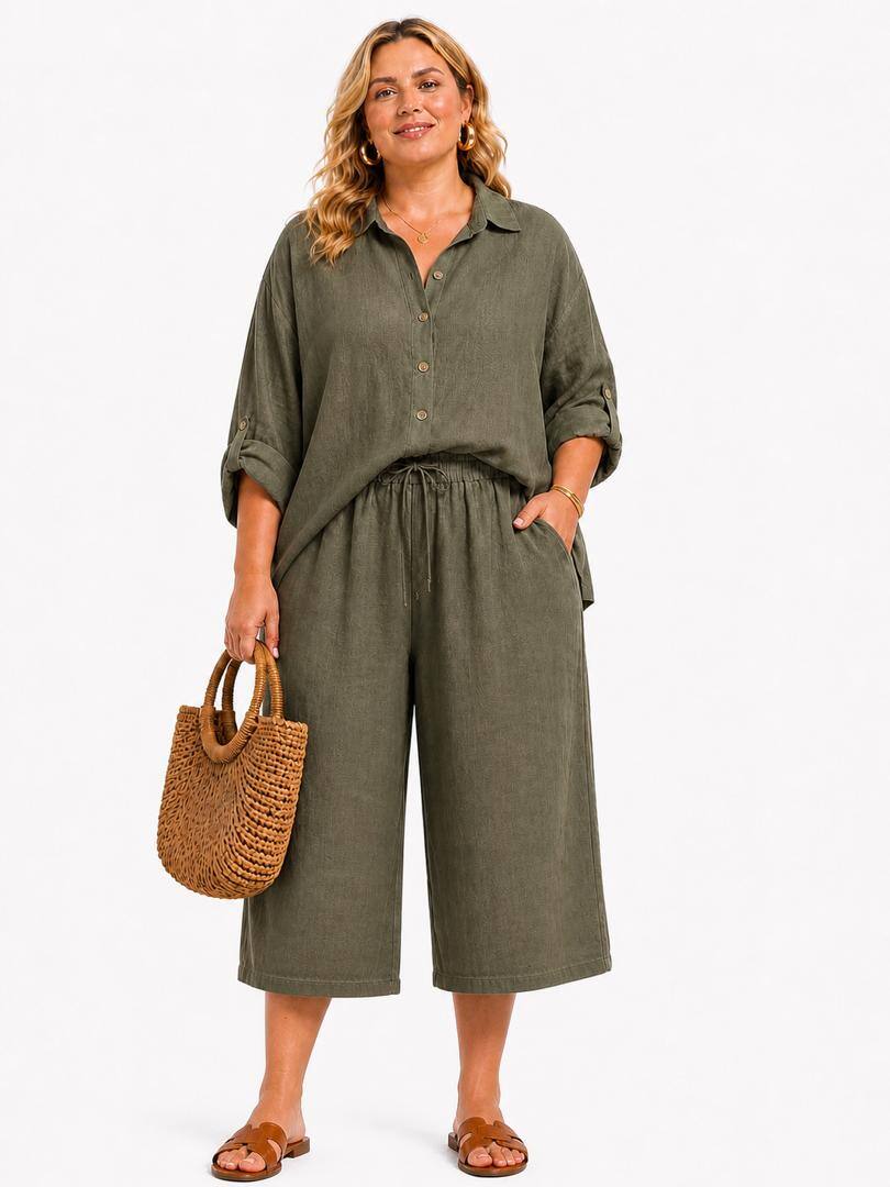 Woman wearing a green pair of loose fitting cropped trousers holding a woven bag on a white background