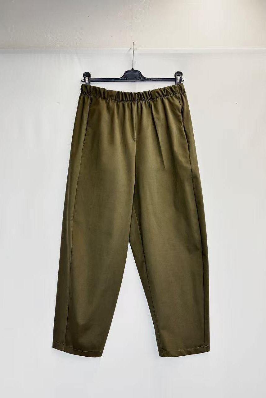 Olive green wide-leg cropped pants with an elastic waistband, hanging on a black hanger against a white backdrop.