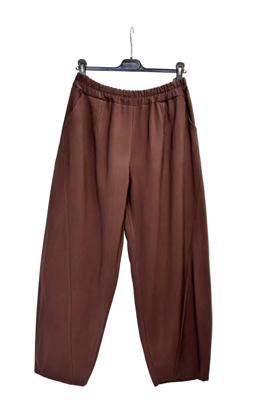 A pair of brown wide-leg cropped pants with an elastic waistband, hanging on a black hanger against a plain white wall.