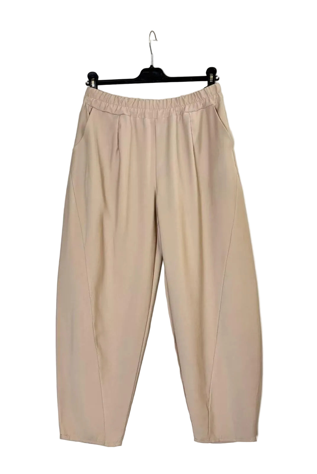A pair of beige wide-leg cropped pants with an elastic waistband, hanging on a black hanger against a plain off-white wall.