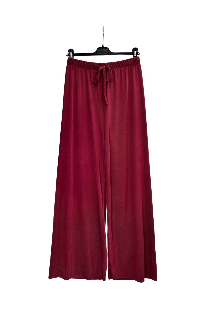 A pair of wide-leg knit pants in a deep burgundy red