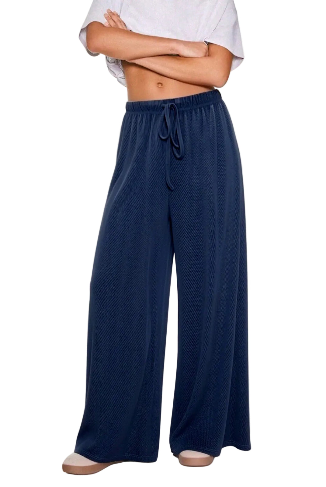 A person wearing loose, wide-leg navy lounge pants with a drawstring waist
