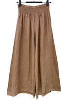 Brown wide-leg pants hanging on a white background