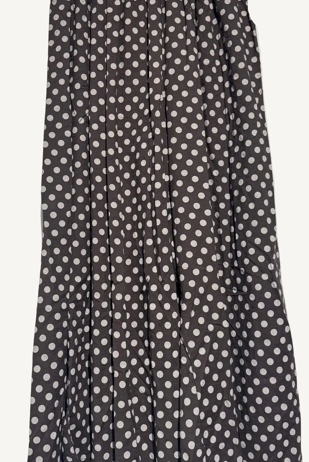 Brown trousers with white polka dot pattern on a plain background