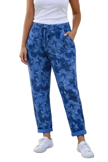 Person wearing blue floral pants with a white background.