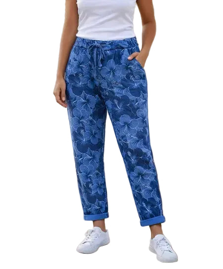Person wearing blue floral pants with a white background.
