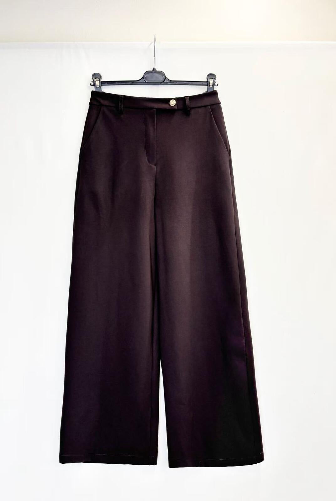 Dark brown wide-leg trousers hanging on a black hanger against a plain white background.