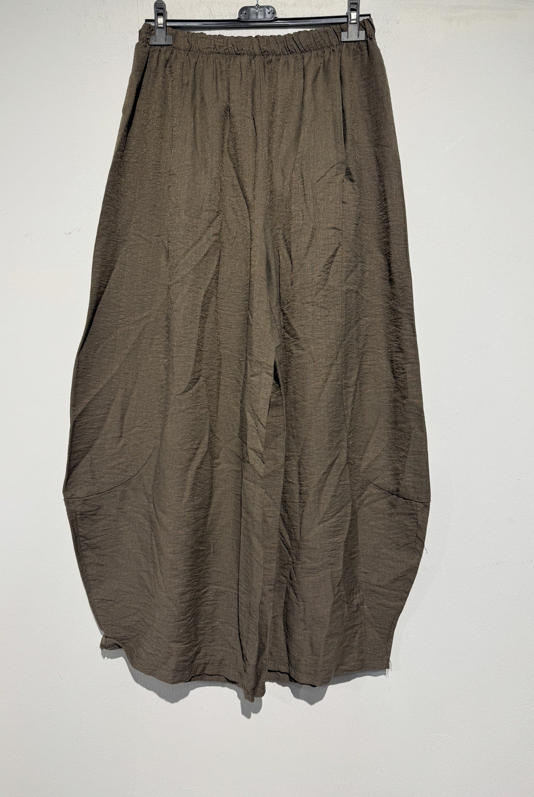 Brown pants hanging on a rack against a white background