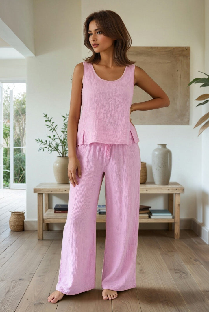 Woman wearing a pink tank top and pants in a home setting