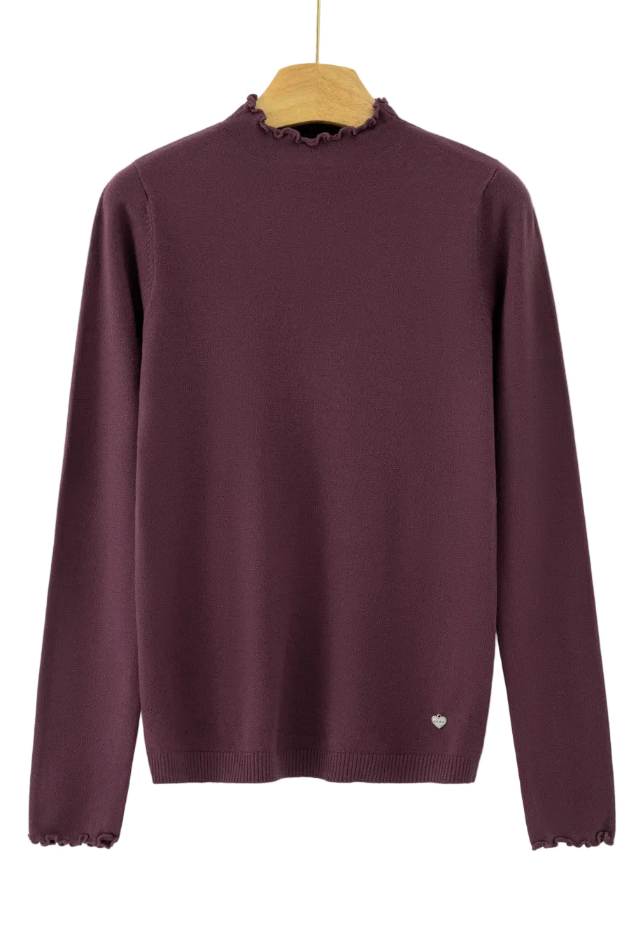 A long-sleeve knit sweater in deep plum purple, hanging on a wooden hanger against a plain white background. The sweater features a mock neck with delicate ruffled trim, matching ruffled trim along the cuffs, and a small white embroidered heart on the lower left hem.