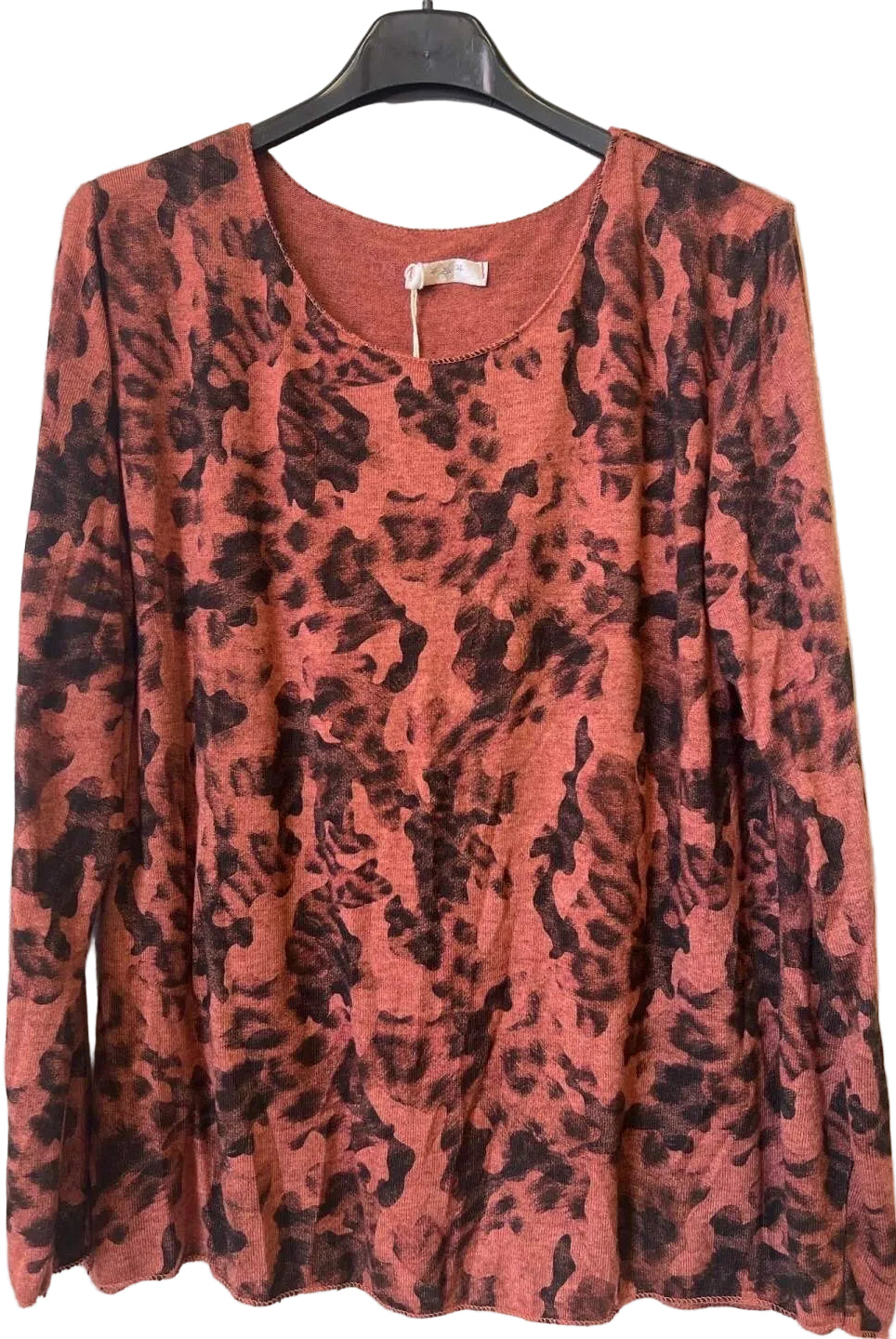 A long-sleeve crewneck top with a rust-orange and black camouflage print