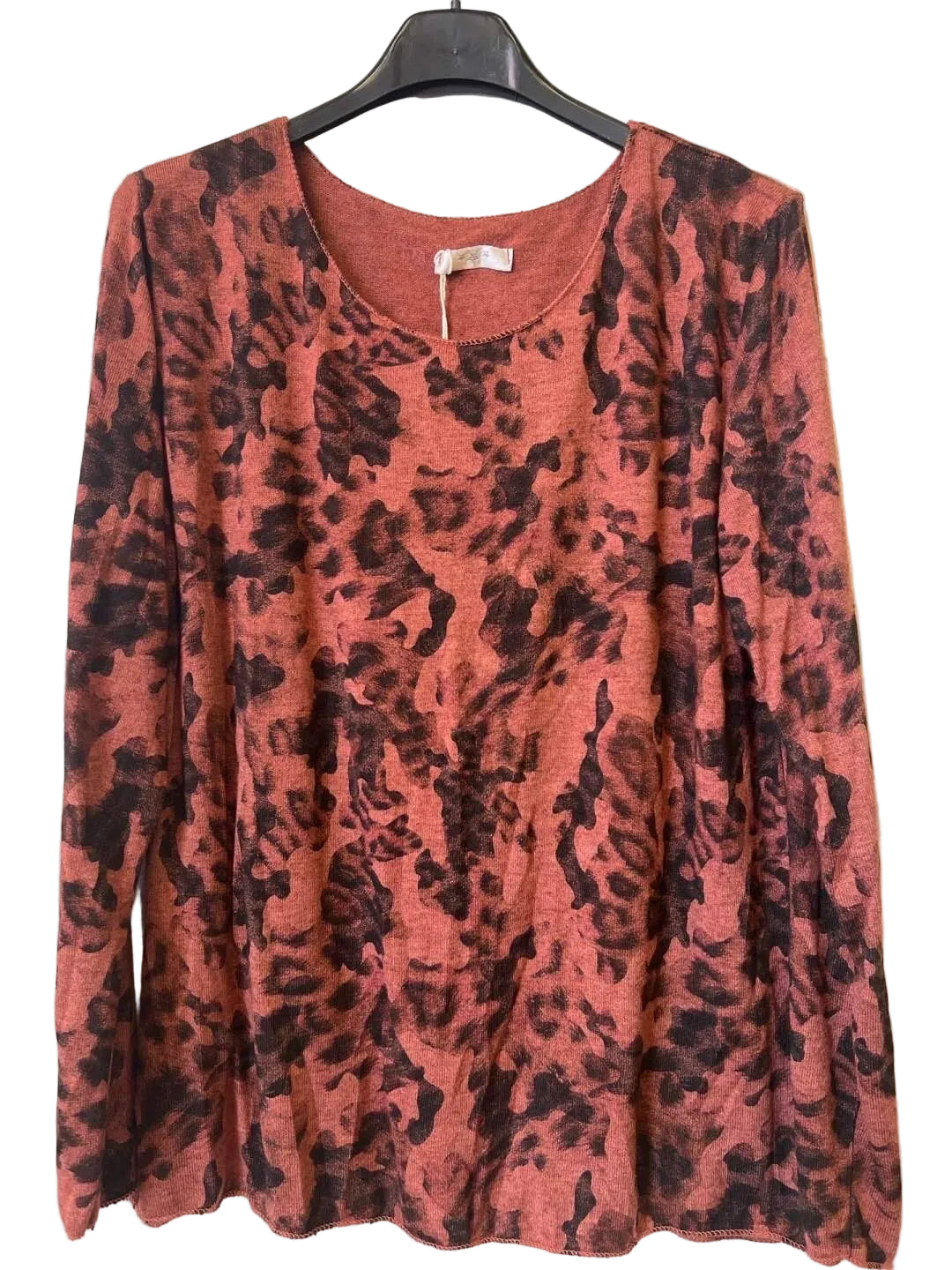 A long-sleeve crewneck top with a rust-orange and black camouflage print