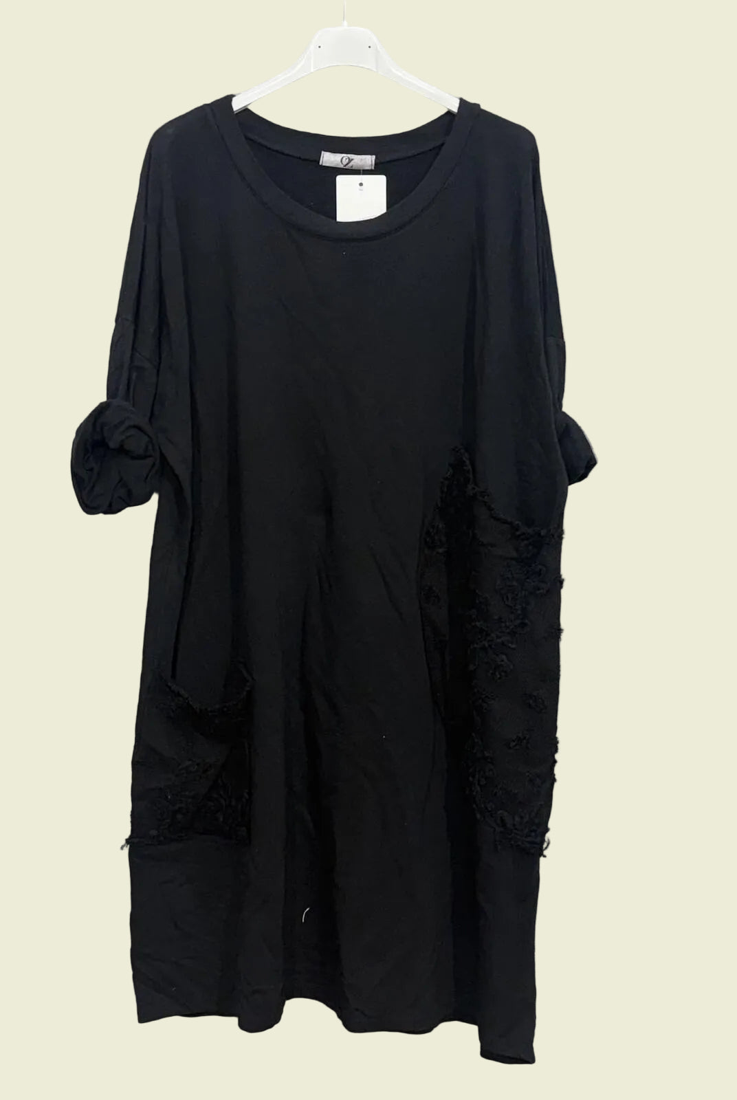 Black dress on a hanger with round neck and feature pockets