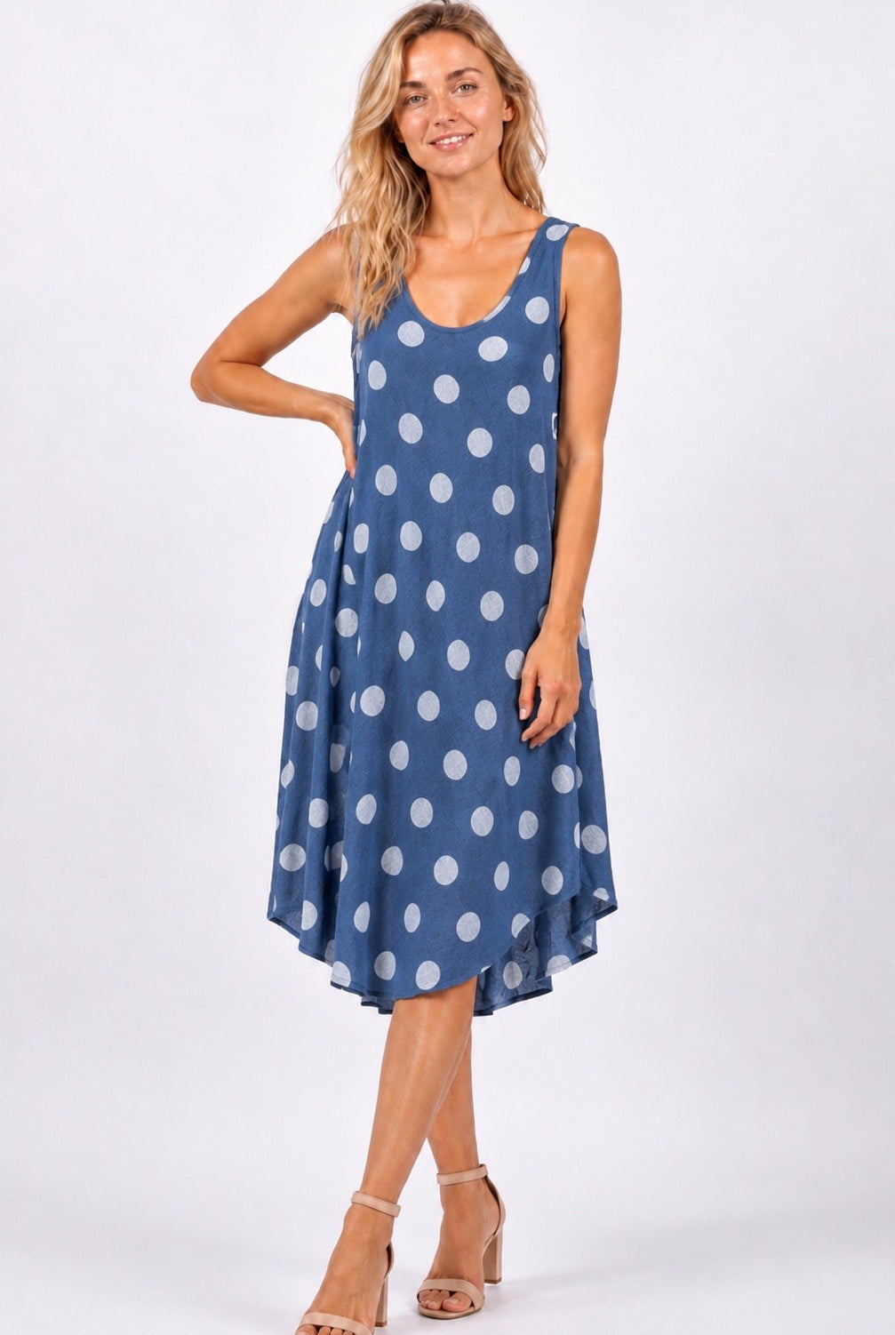 Woman wearing a blue polka dot dress on a white background