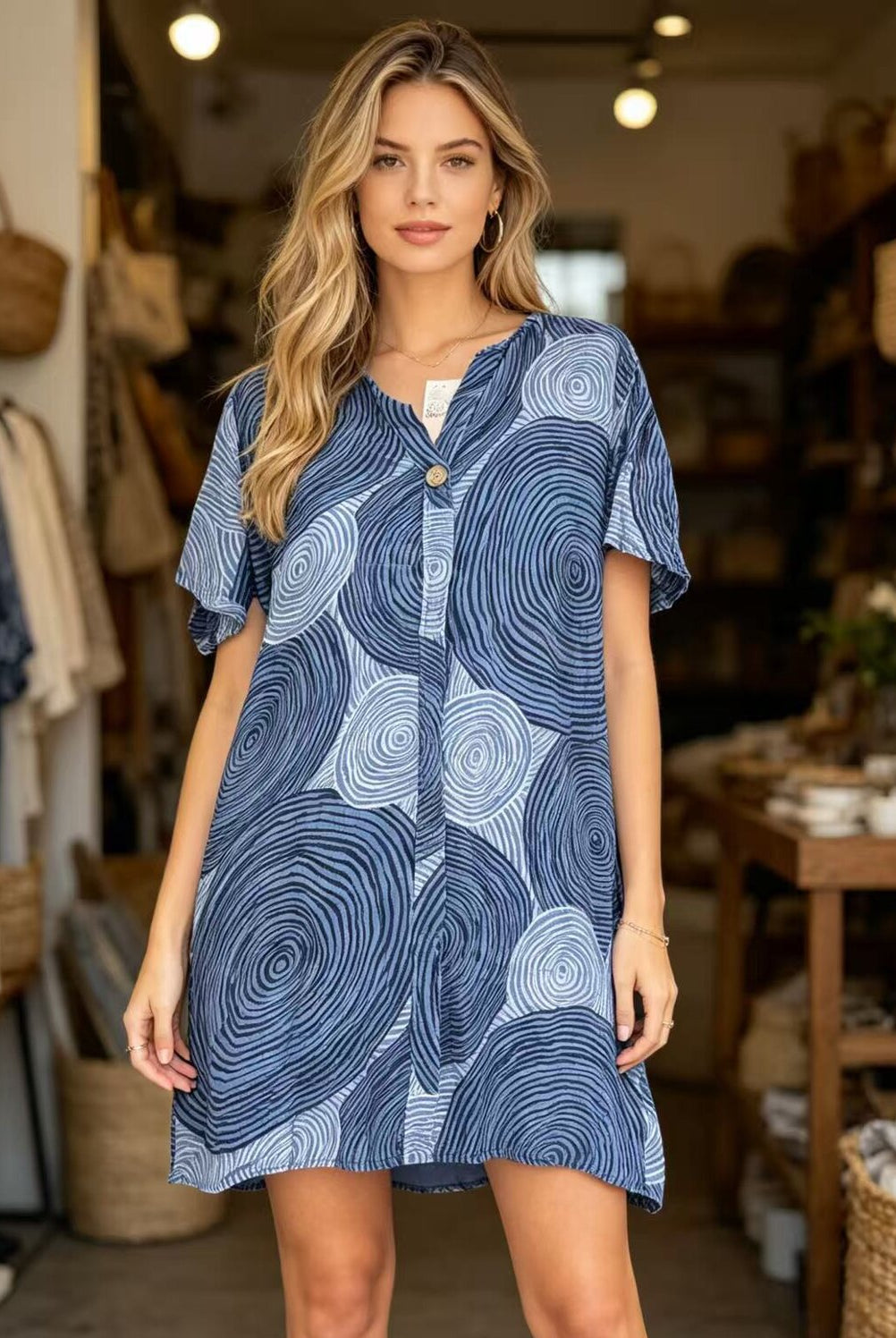 Woman wearing a blue patterned dress in a store setting