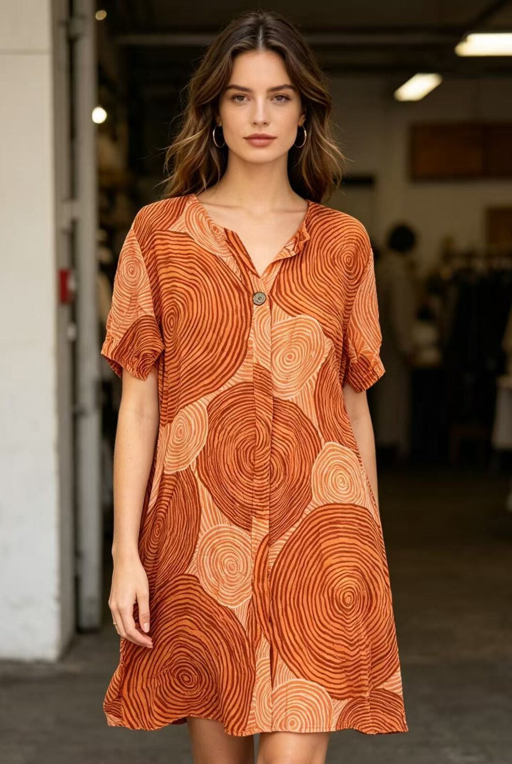 Woman wearing an orange patterned dress in a casual setting