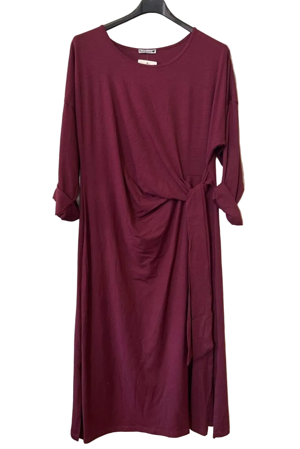 A long-sleeve, crew-neck dress in deep burgundy. The dress features a gathered twist detail at the waist and a side tie.