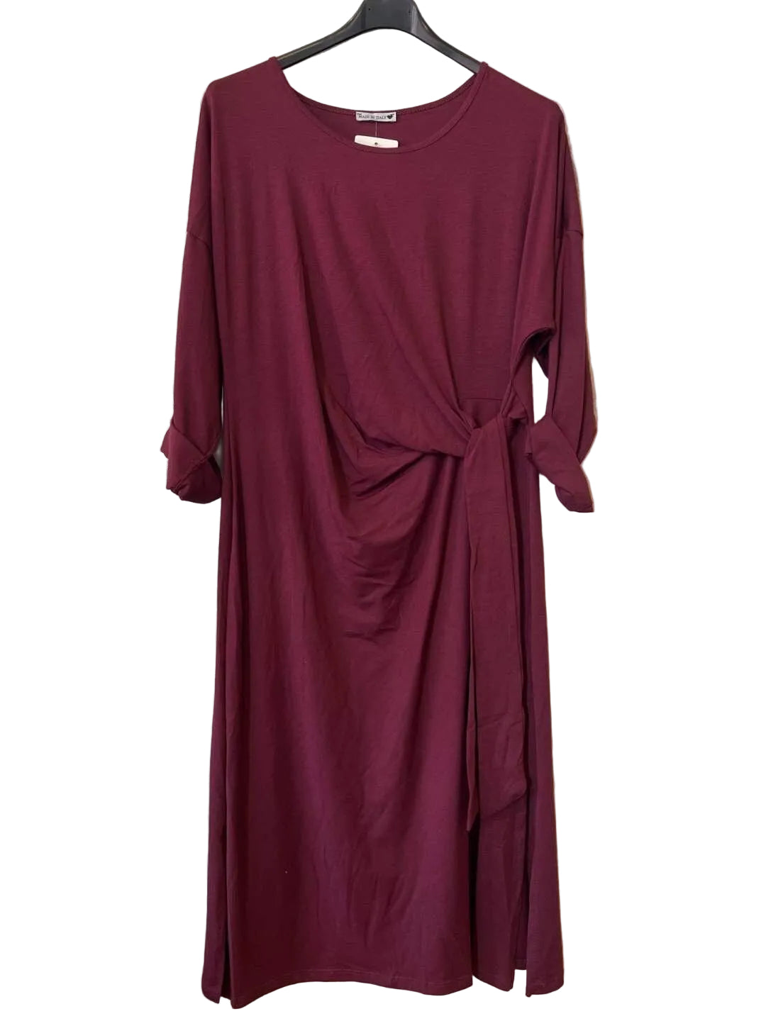 A long-sleeve, crew-neck dress in deep burgundy. The dress features a gathered twist detail at the waist and a side tie.