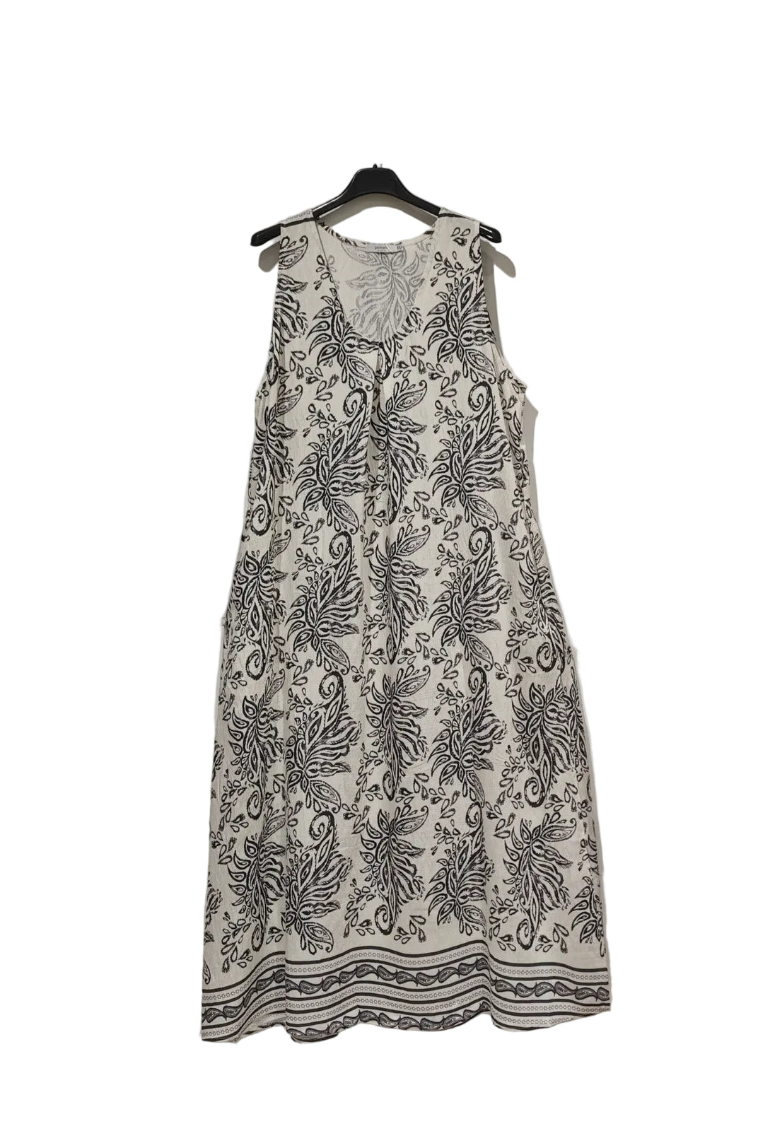 White dress with black floral pattern on a hanger against a white background