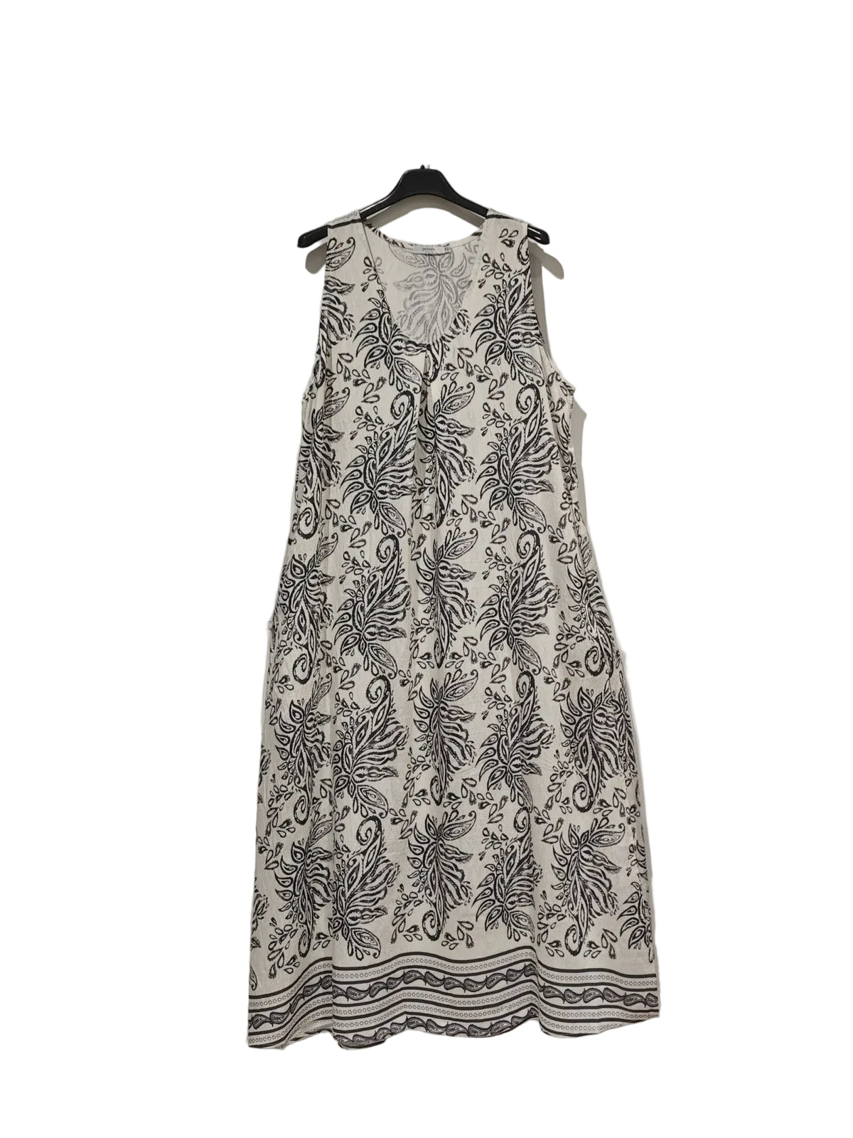 White dress with black floral pattern on a hanger against a white background