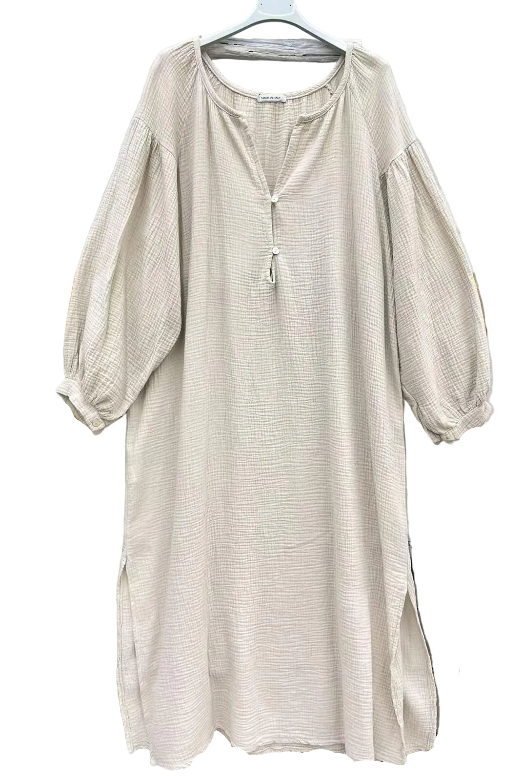A light beige textured dress with three-quarter puff sleeves and a split neckline with a tassel detail