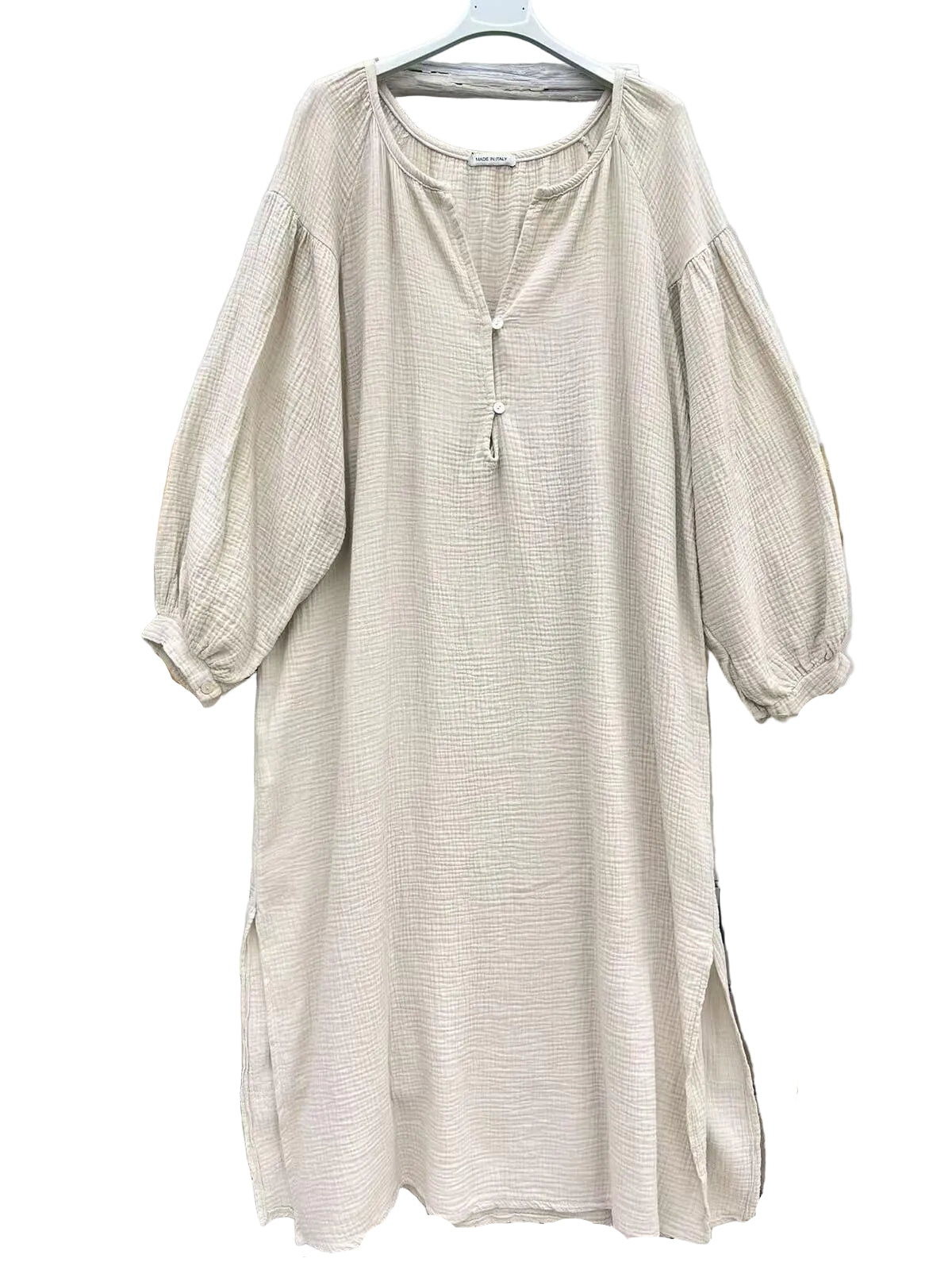 A light beige textured dress with three-quarter puff sleeves and a split neckline with a tassel detail