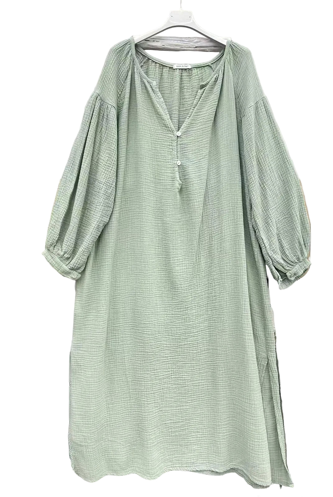 A light sage green textured dress with balloon sleeves and a split neckline, hanging on a white hanger