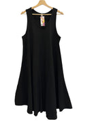 Black sleeveless dress on a hanger against a white wall.
