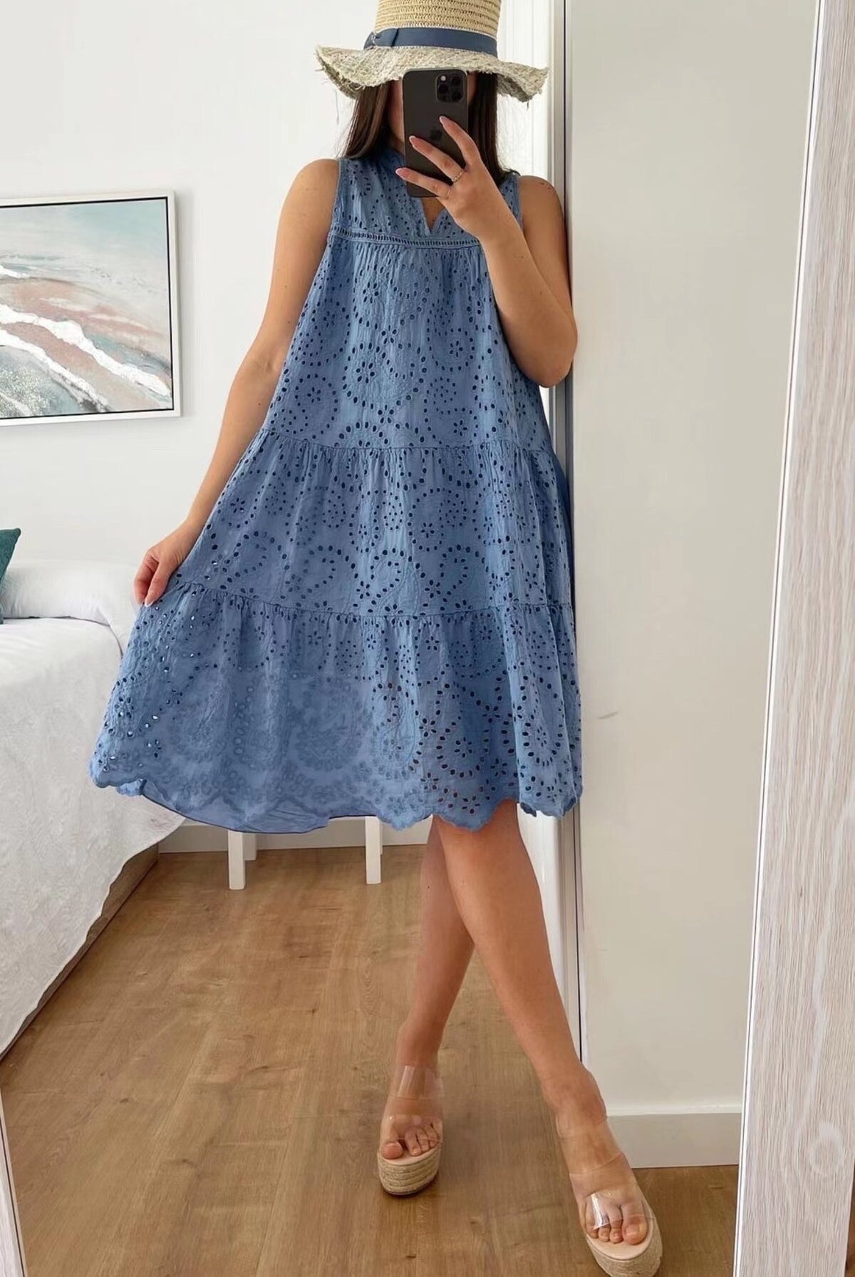 Person wearing a blue lace dress taking a mirror selfie.